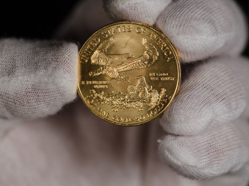Gouden American Eagle munt van 1 troy ounce in een witte handschoen