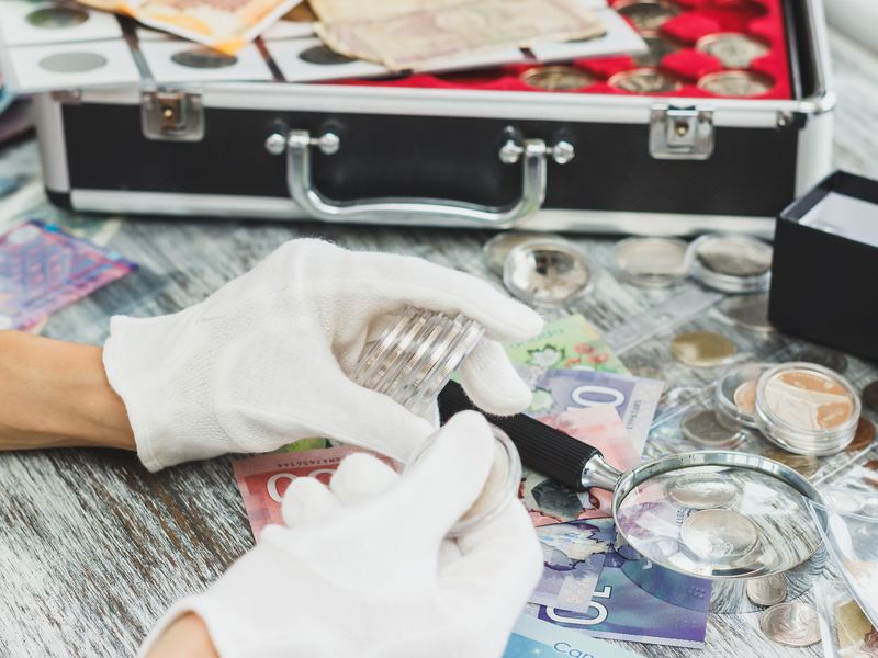 Bankbiljetten en munten in capsules op tafel met een vergrootglas